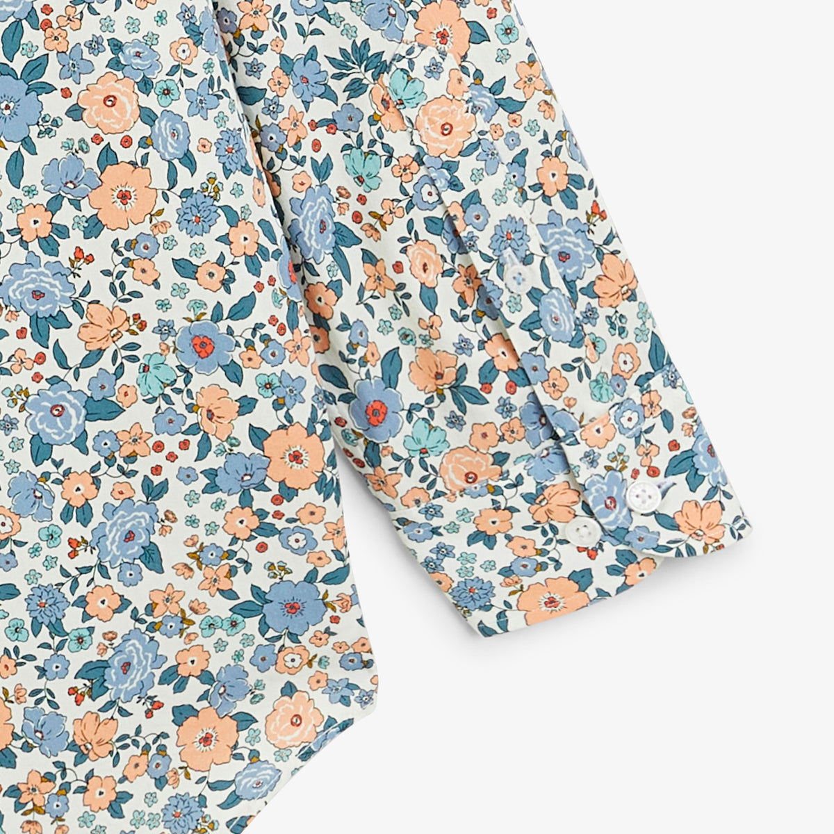 Détail des manches et des poignets de la chemise à imprimé fleuri bleu.