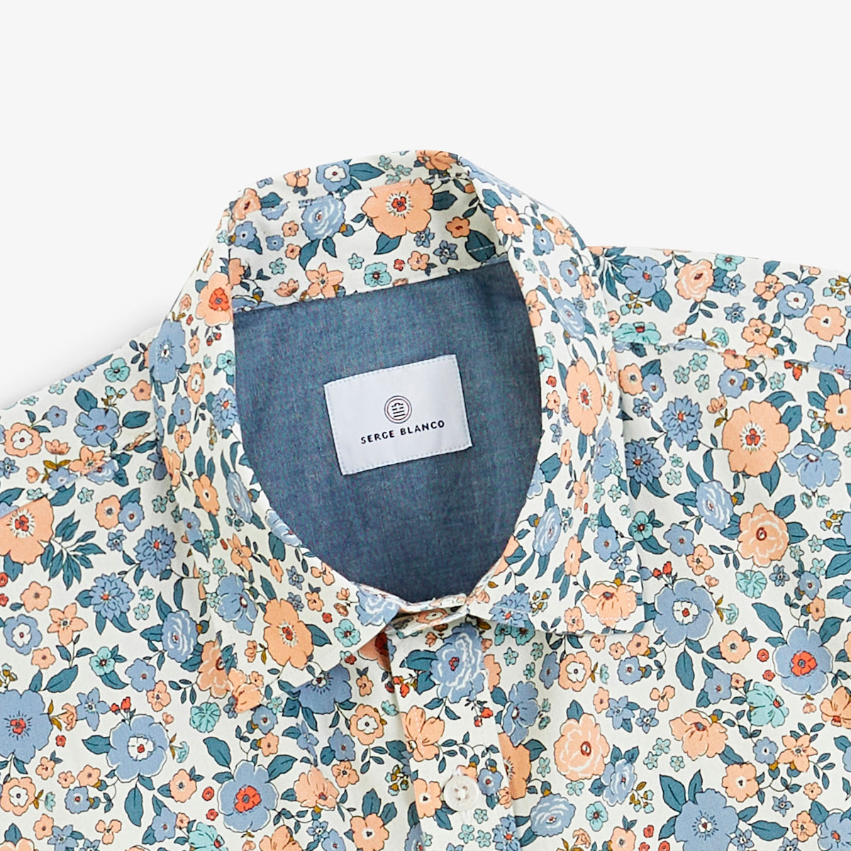 Détail du col et de l'imprimé fleuri de la chemise manches longues bleue.