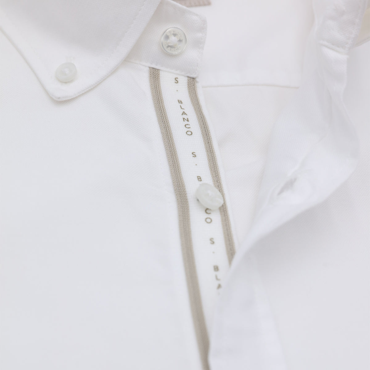 Détail du col boutonné et de la patte de boutonnage de la chemise Oxford blanche Sangle SB.