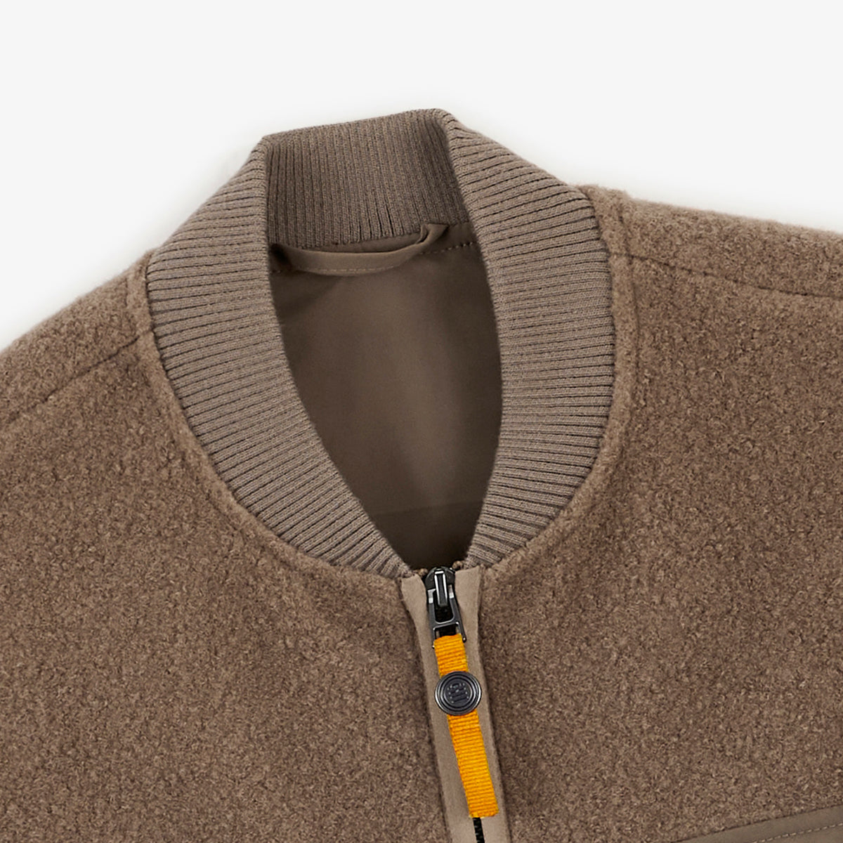 Détail du col côtelé et de la fermeture zippée du gilet polaire Marcel beige.