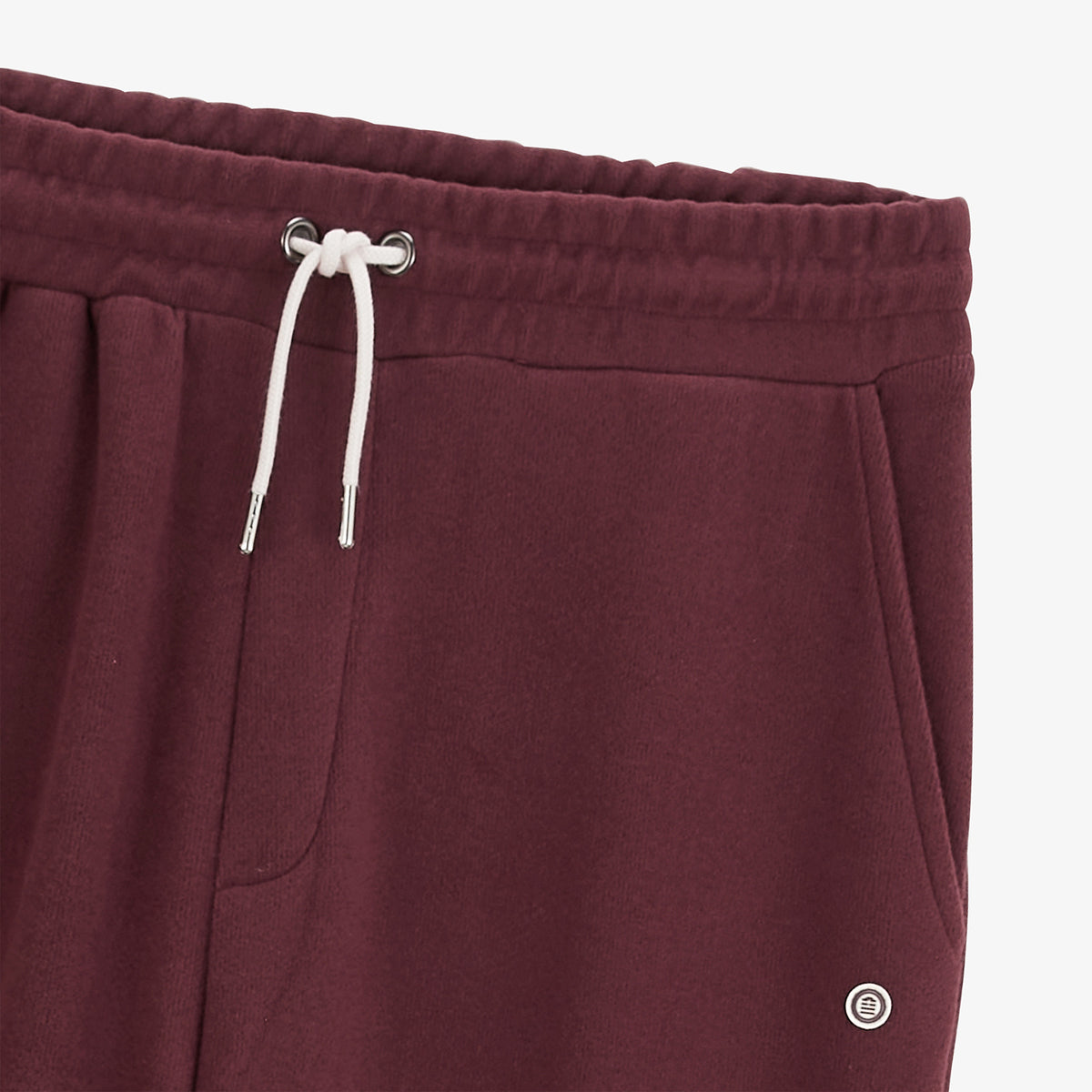 Détail de la taille élastiquée, du cordon blanc et de la poche du jogging Paolo rouge.