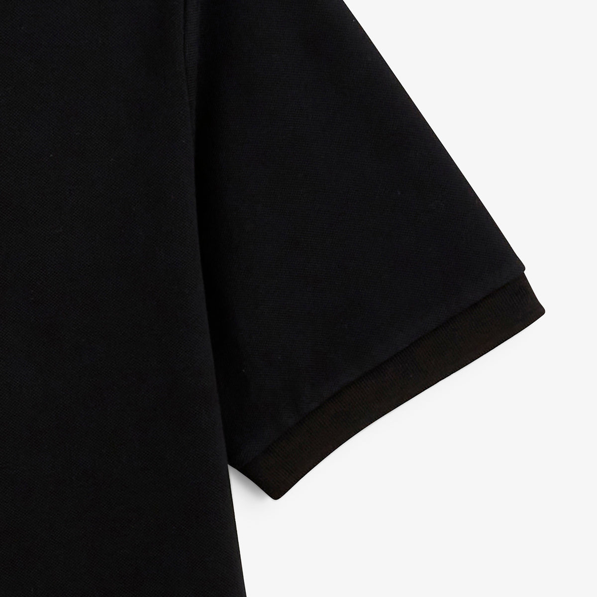 Détail de la manche courte et de la maille piquée du polo Lucas noir SERGE BLANCO.