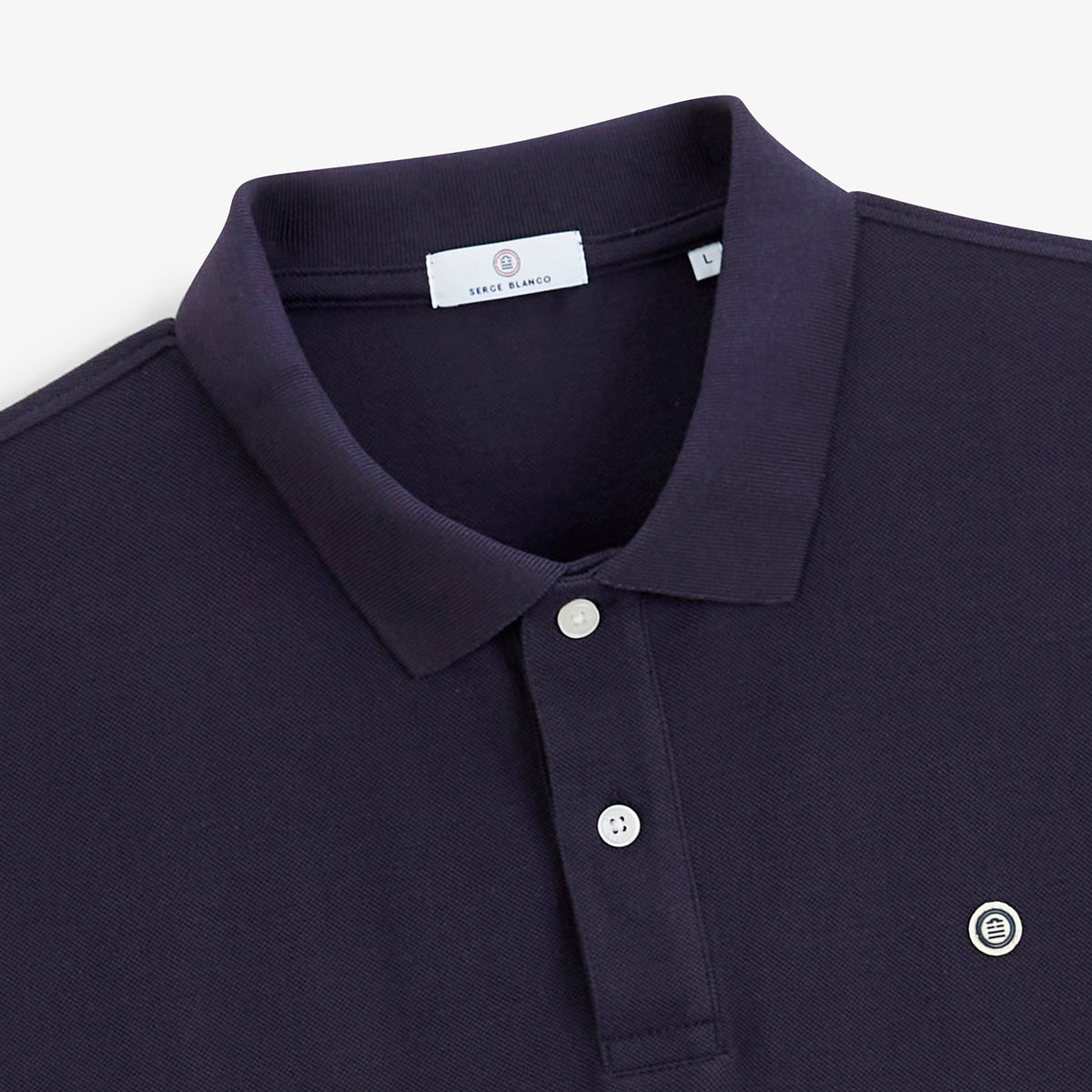 Détail du col, des boutons et du logo du polo piqué Lucas bleu marine foncé.
