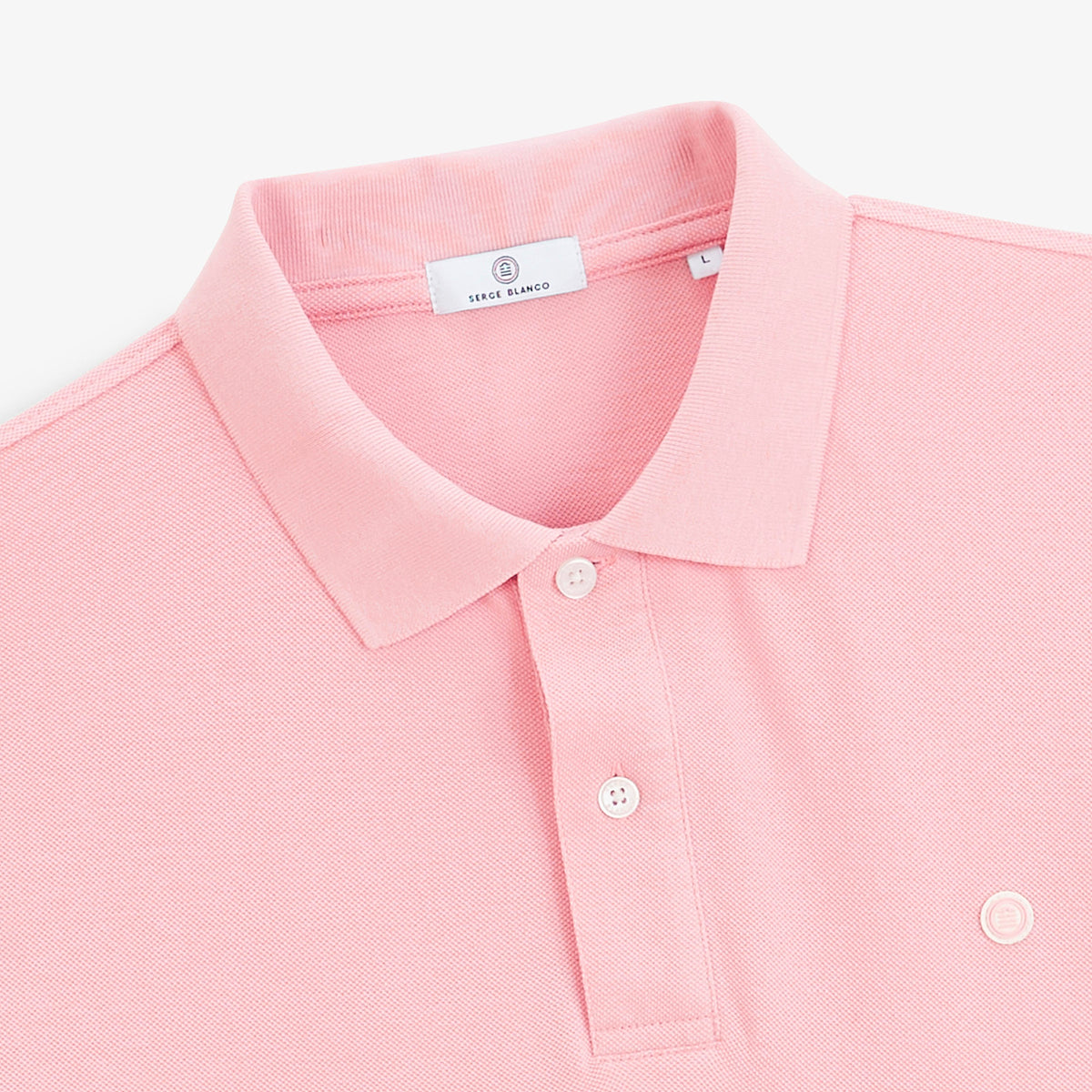 Détail du col, des boutons et du logo du polo piqué Lucas rose.