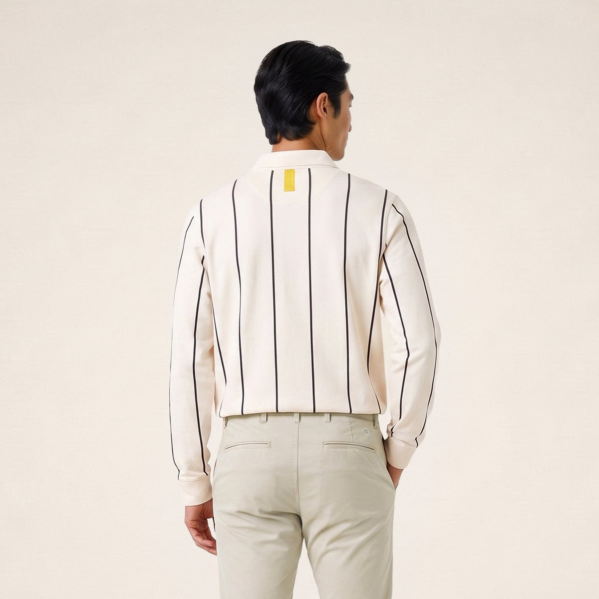 Polo da rugby a maniche lunghe a righe color bianco sporco indossata da un modello, vista da dietro.