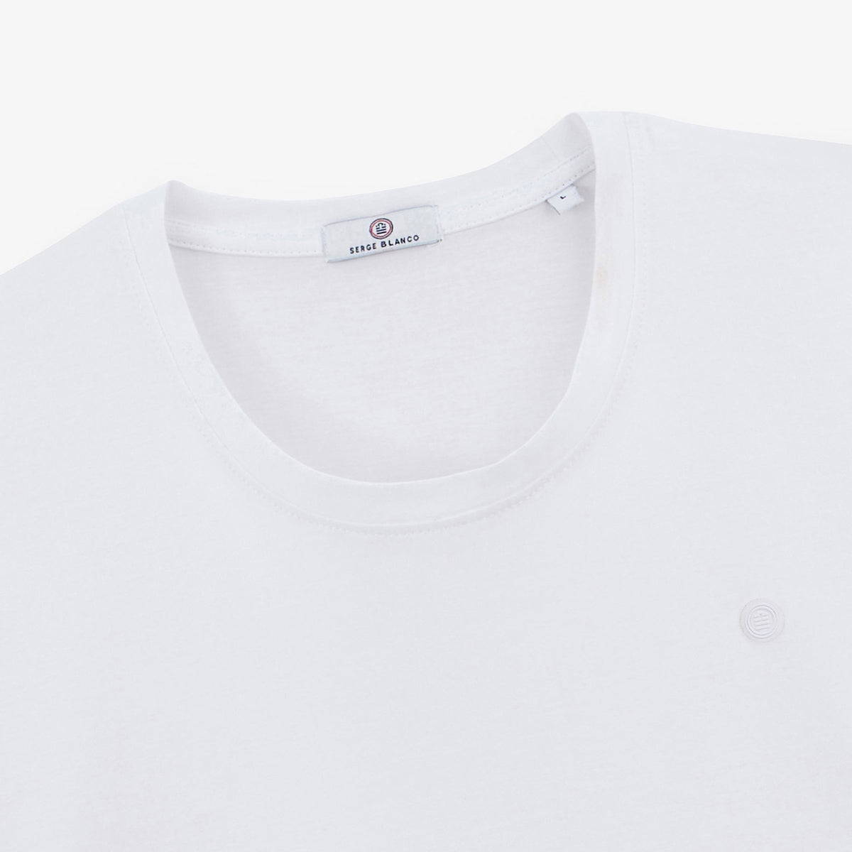 Détail du col rond et du logo poitrine du T-shirt Théo blanc SERGE BLANCO.
